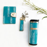 a photo of multiple mint arrow products made of batik including a passport cover, a key fob and a tumbler against a white background