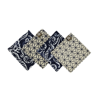 batik coasters lined up showcasing the front and back of the batik pattern in blue nautical fern against a neutral background