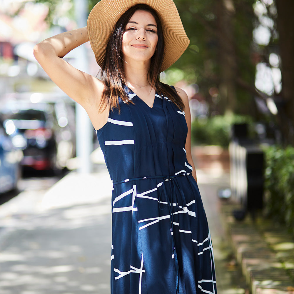 a women standing by the street styling batik maxi dress in navy brush and straw hat