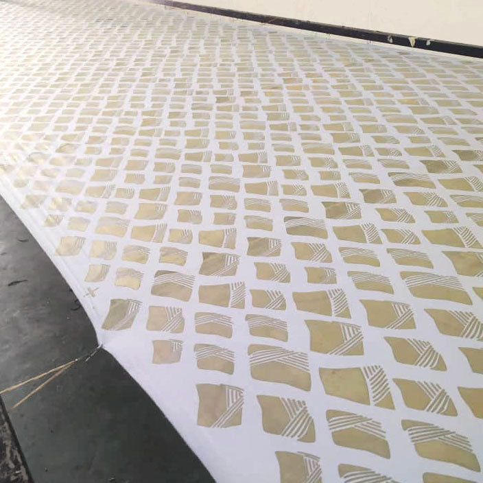 a photo of white fabric in a process of drying from waxing in nasi lemak pattern. this is a process of batik making