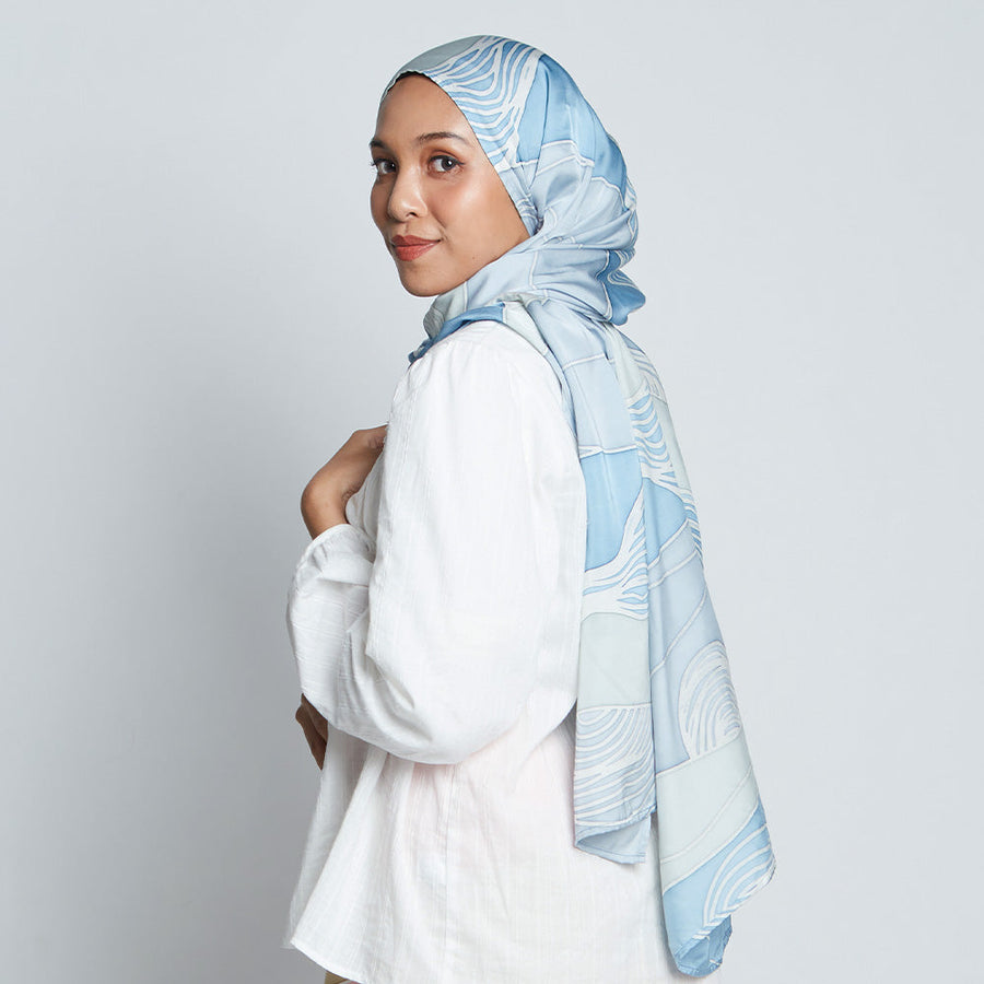Woman wearing a blue silk cotton batik scarf which was hand-painted inspired from Bukit Collection interpreted by artists from the hills of Malaysia.
