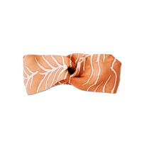 a whitebox photo of an authentic batik in the pattern peach fern showcasing the details on the front of the headband