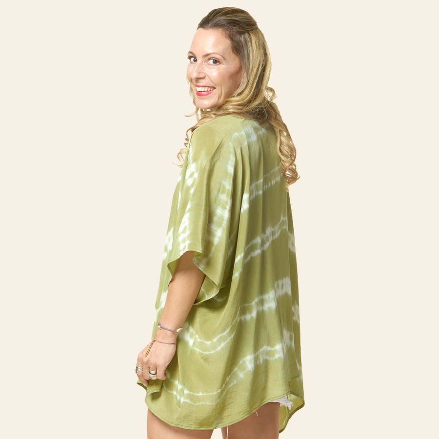 Model posing with short Shibori Kimono in Olive handcrafted batik print, made in Malaysia. Back view.