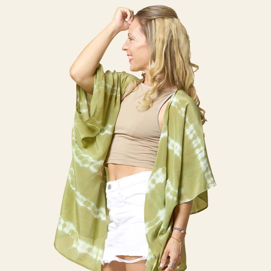 Model posing with short Shibori Kimono in Olive handcrafted batik print, made in Malaysia. Side view.