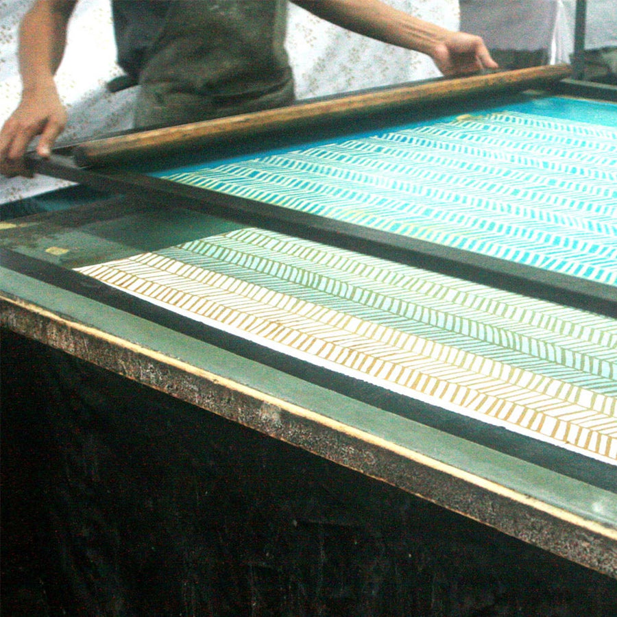 a batik artisan in the process of making batik in the process known as silk screening