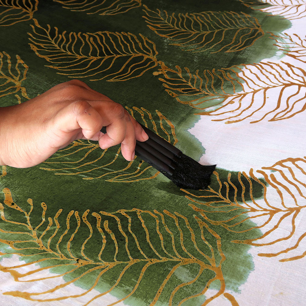 Batik artisan hand painting Fern print using wax resistant traditional Malaysian printing method.